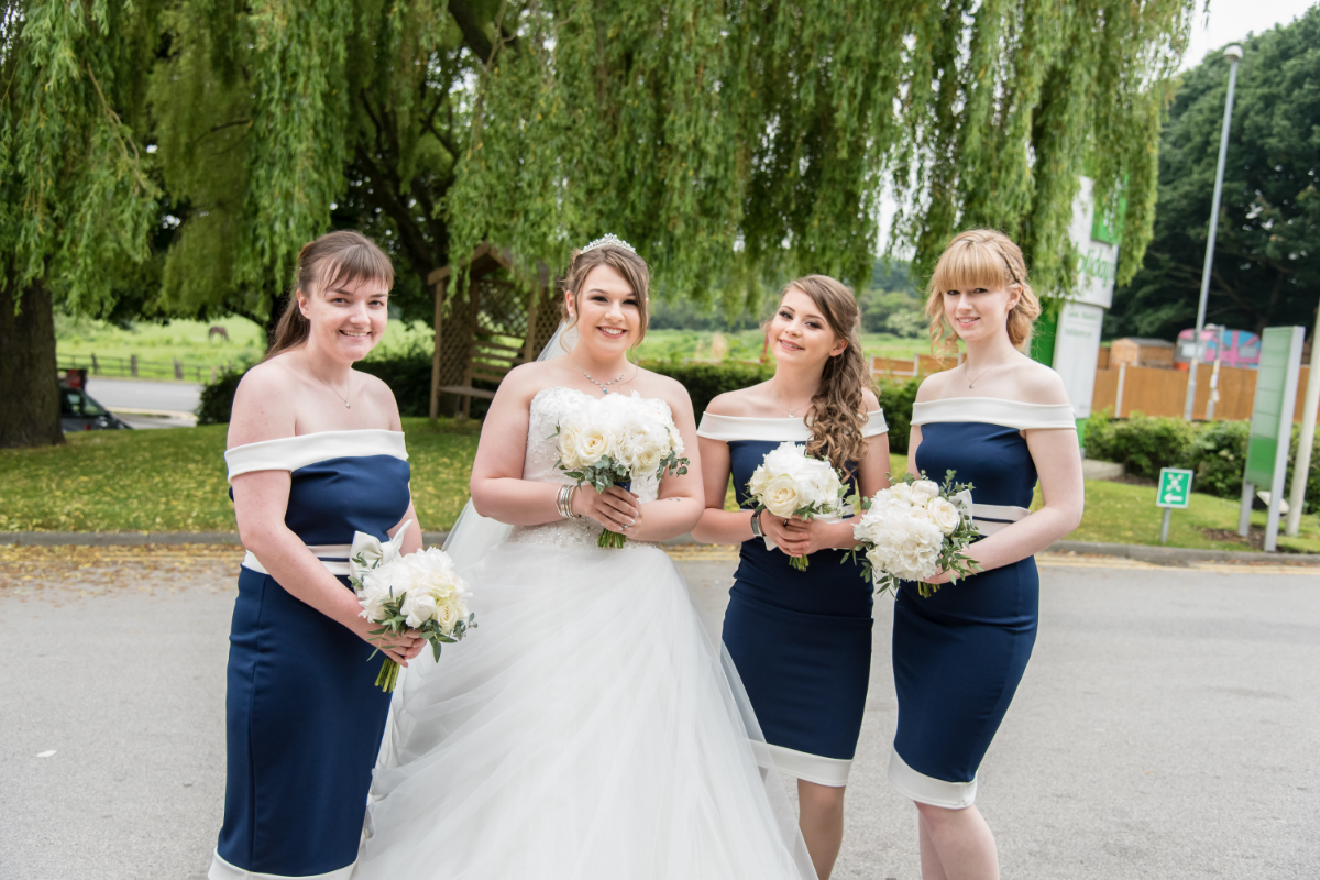 bride with three bridesmaids smiling.